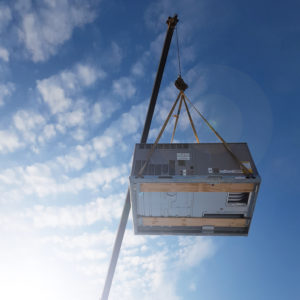 A new HVAC unit being lifted by a crane